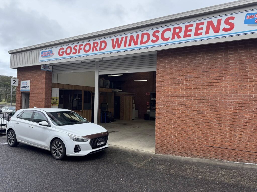 White car parked outside Gosford Windscreens workshop.